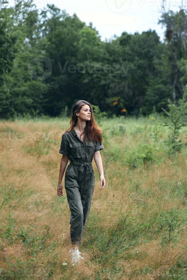 mulher dentro a floresta seco Relva cinzento macacão foto