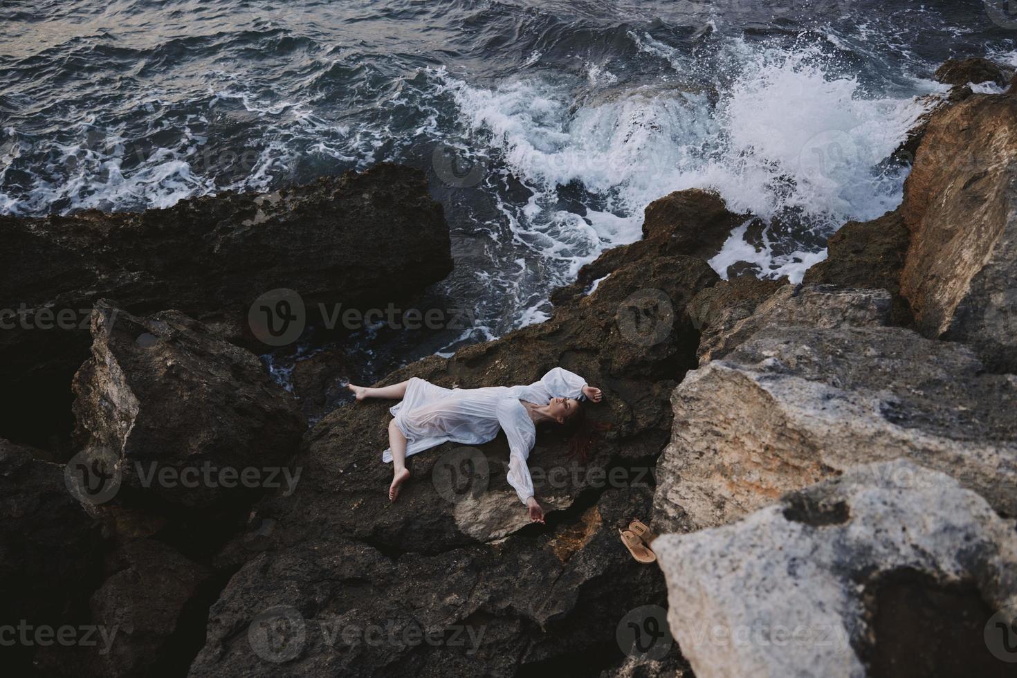 lindo noiva deitado em dela costas em uma rochoso Beira Mar natureza foto