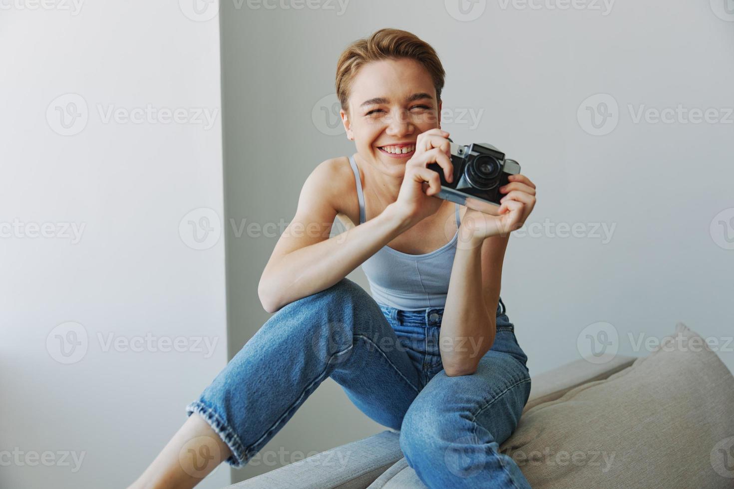 mulher fotógrafo tiroteio dentro estúdio em velho filme Câmera às casa em sofá retrato, branco fundo, livre cópia de espaço, freelance fotógrafo foto