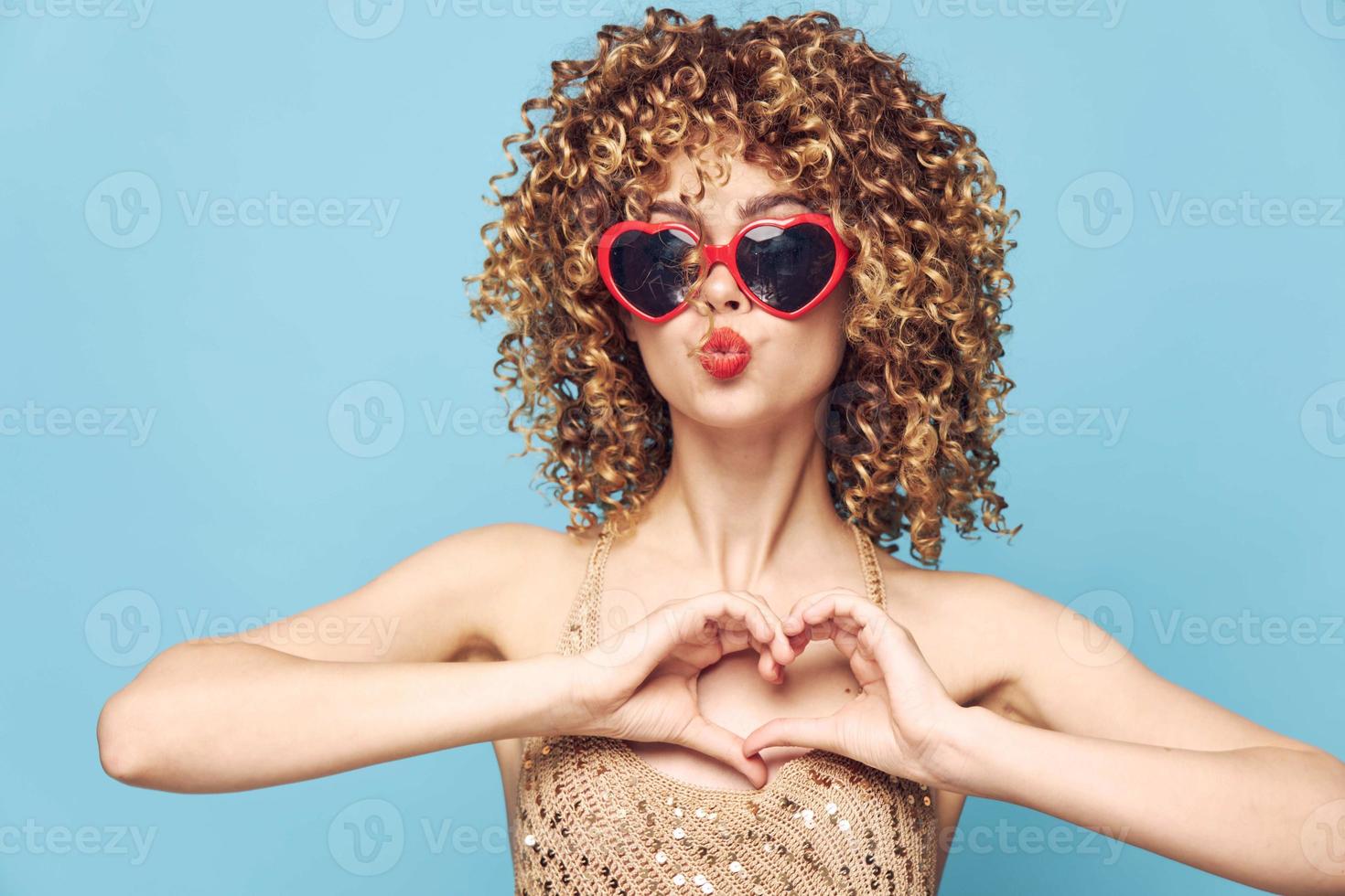 doce senhora glamour em uma azul fundo, coração oculos de sol foto