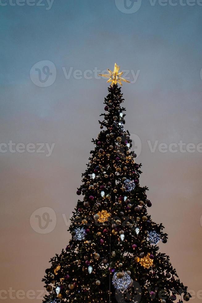 colorida Natal árvore cintilante contra a fundo do a tarde pastel céu foto