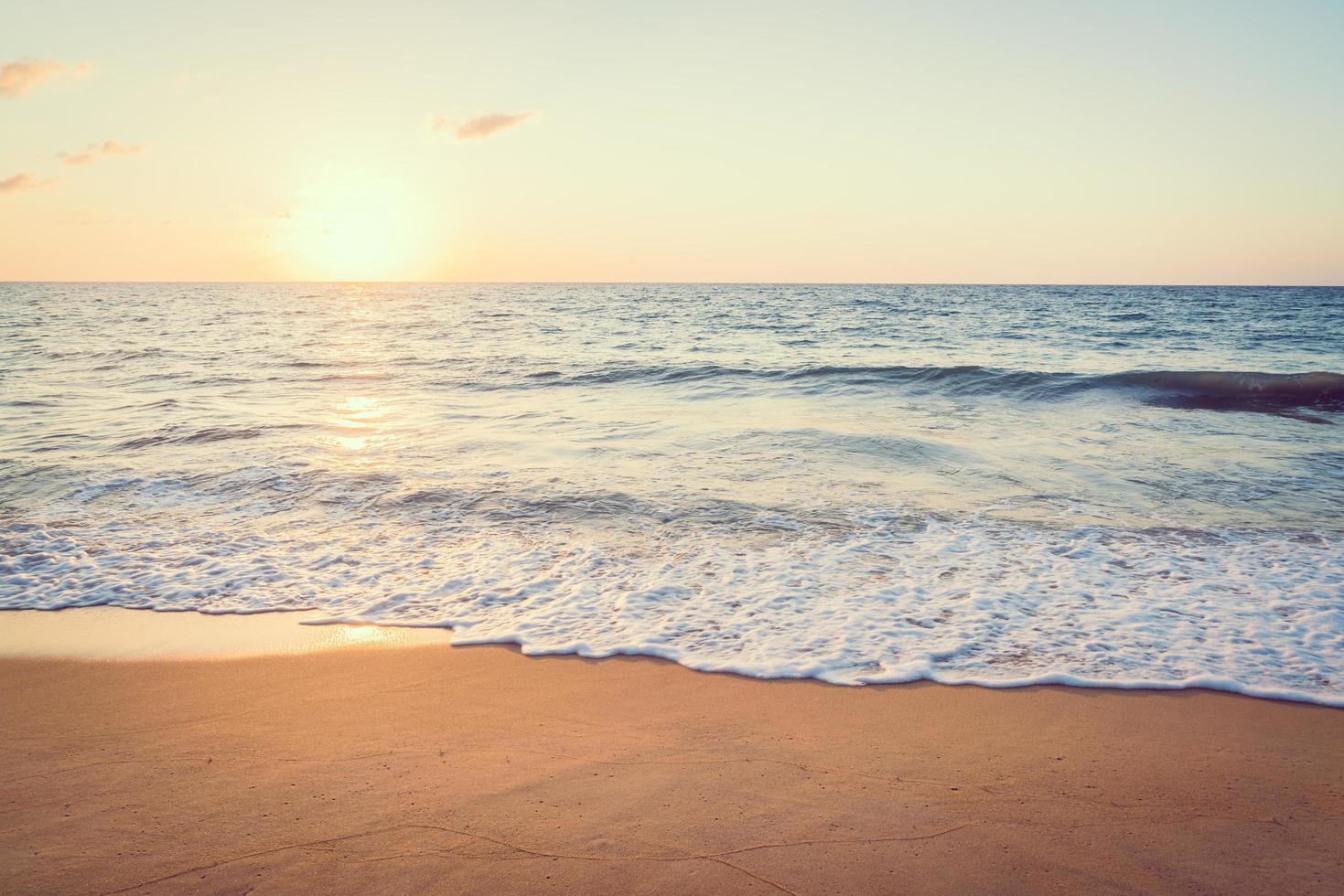 pôr do sol com mar e praia foto