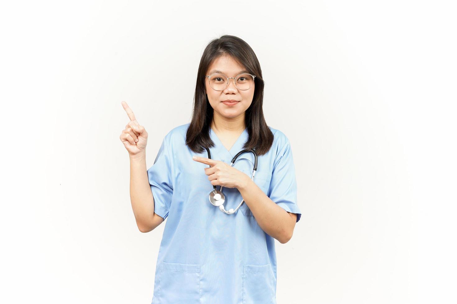 mostrando produtos e apontando lado do ásia jovem médico isolado em branco fundo foto