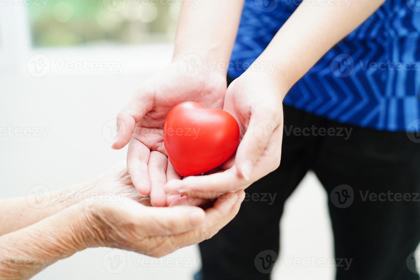 ásia jovem Garoto dar vermelho coração para velho avó com amor e Cuidado. foto