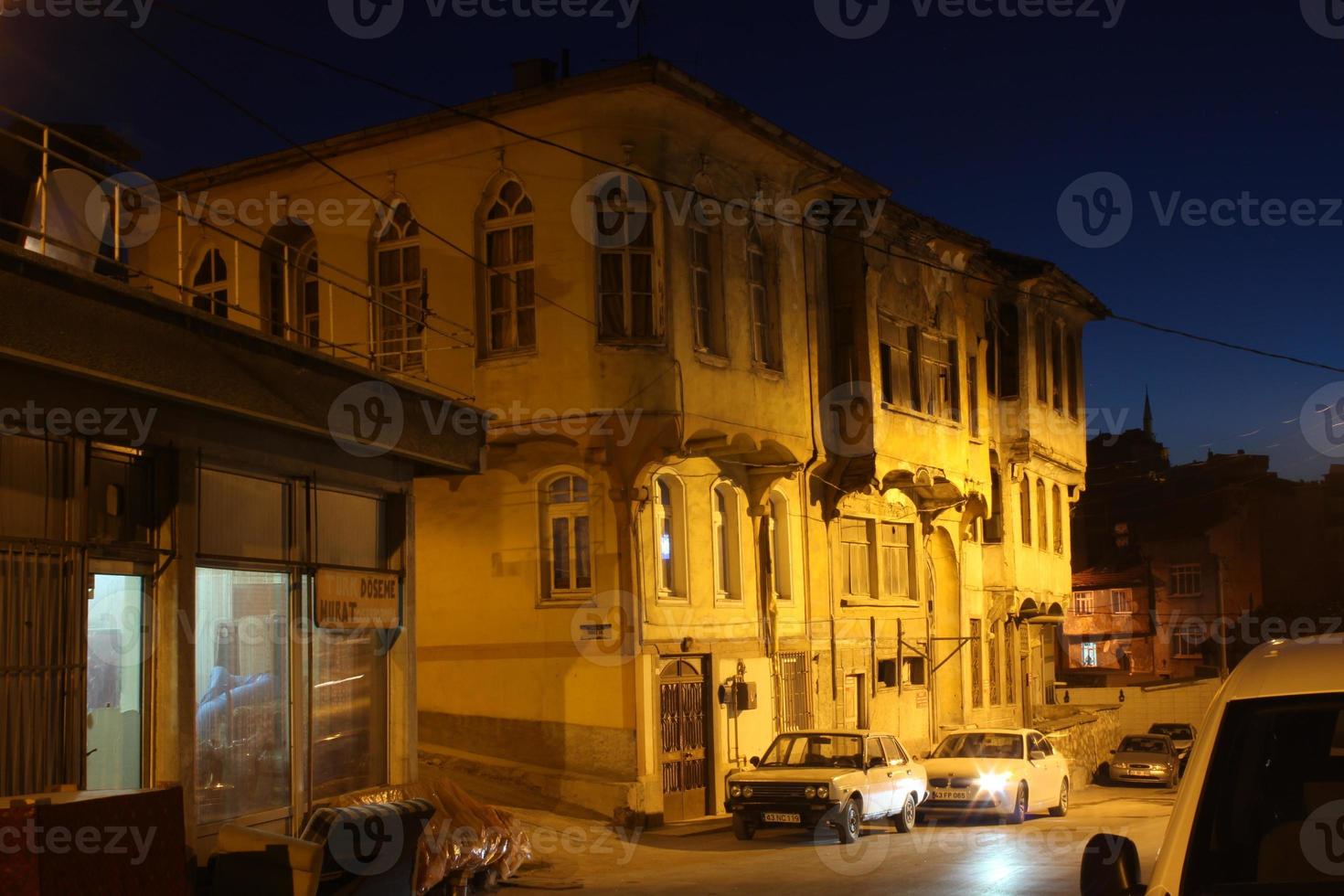 velho turco casa iluminado com rua luminária às noite foto