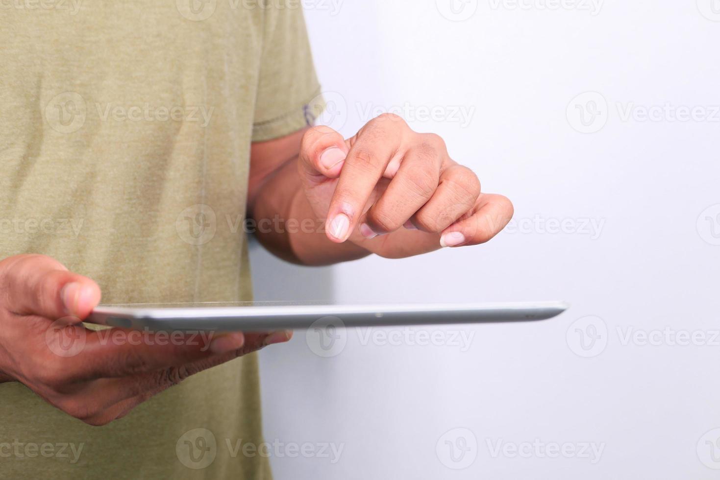 fechar a mão do homem usando um tablet digital foto