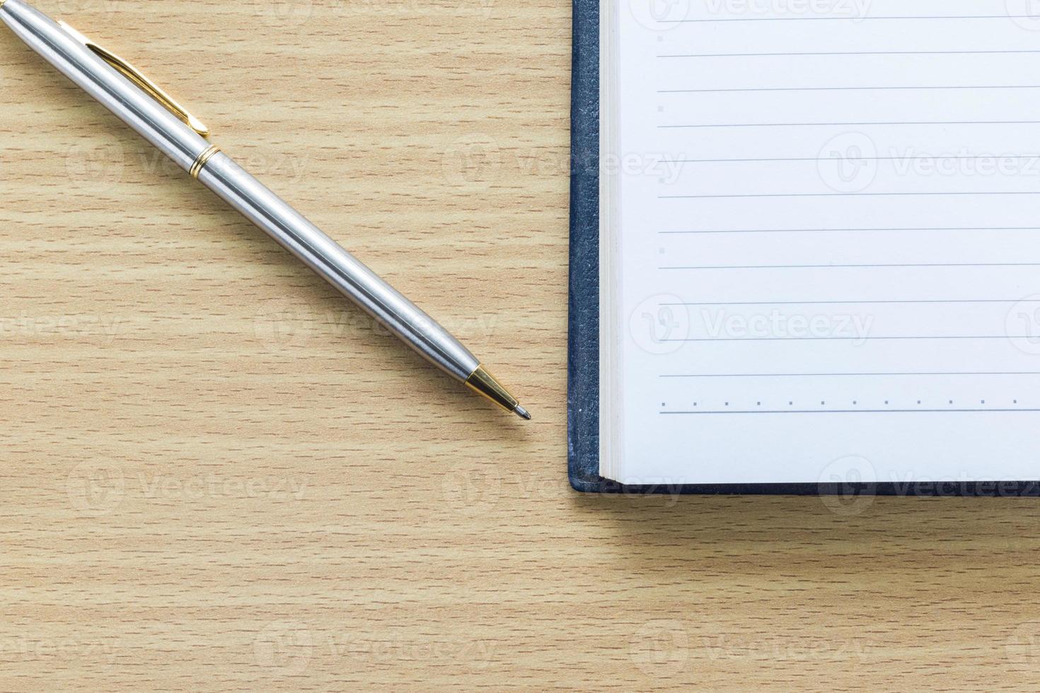 caneta e caderno aberto com página em branco foto