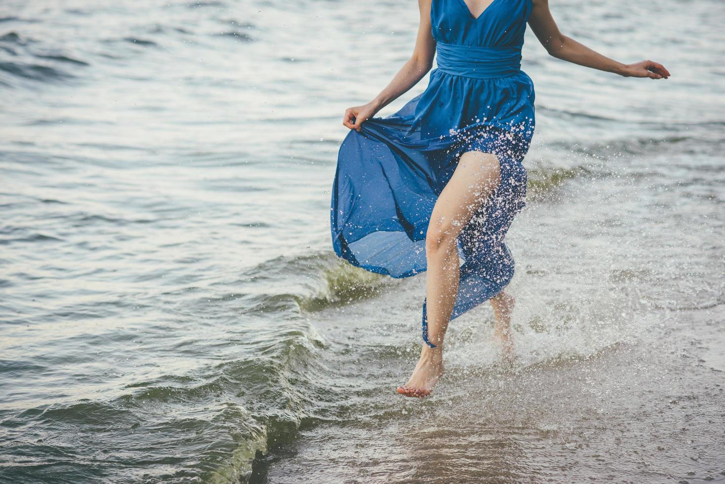 mulher de vestido azul na água foto