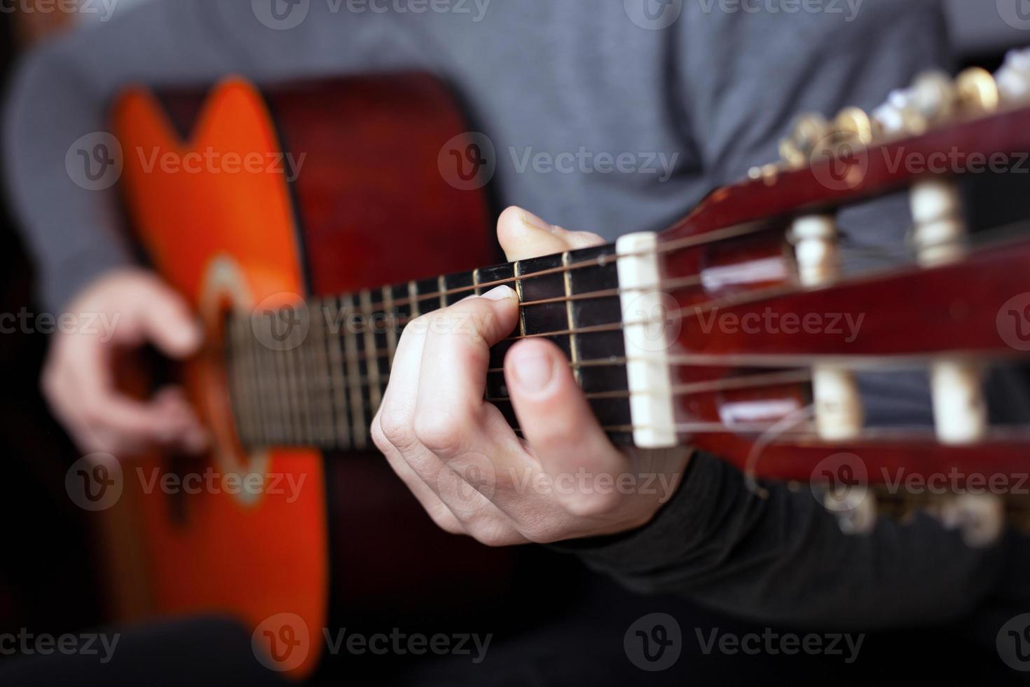 homem tocando violão laranja foto