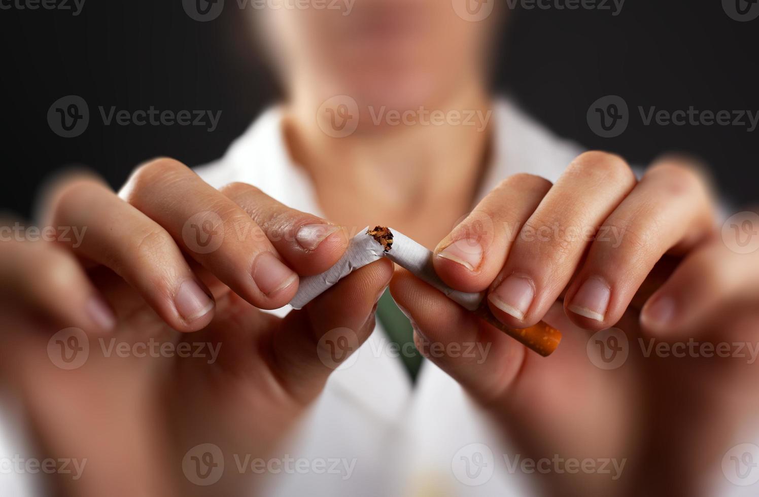 mãos de um médico quebrando close-up de um cigarro foto