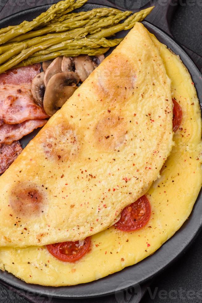 delicioso fresco omelete com cereja tomates, bacon, espargos e especiarias foto