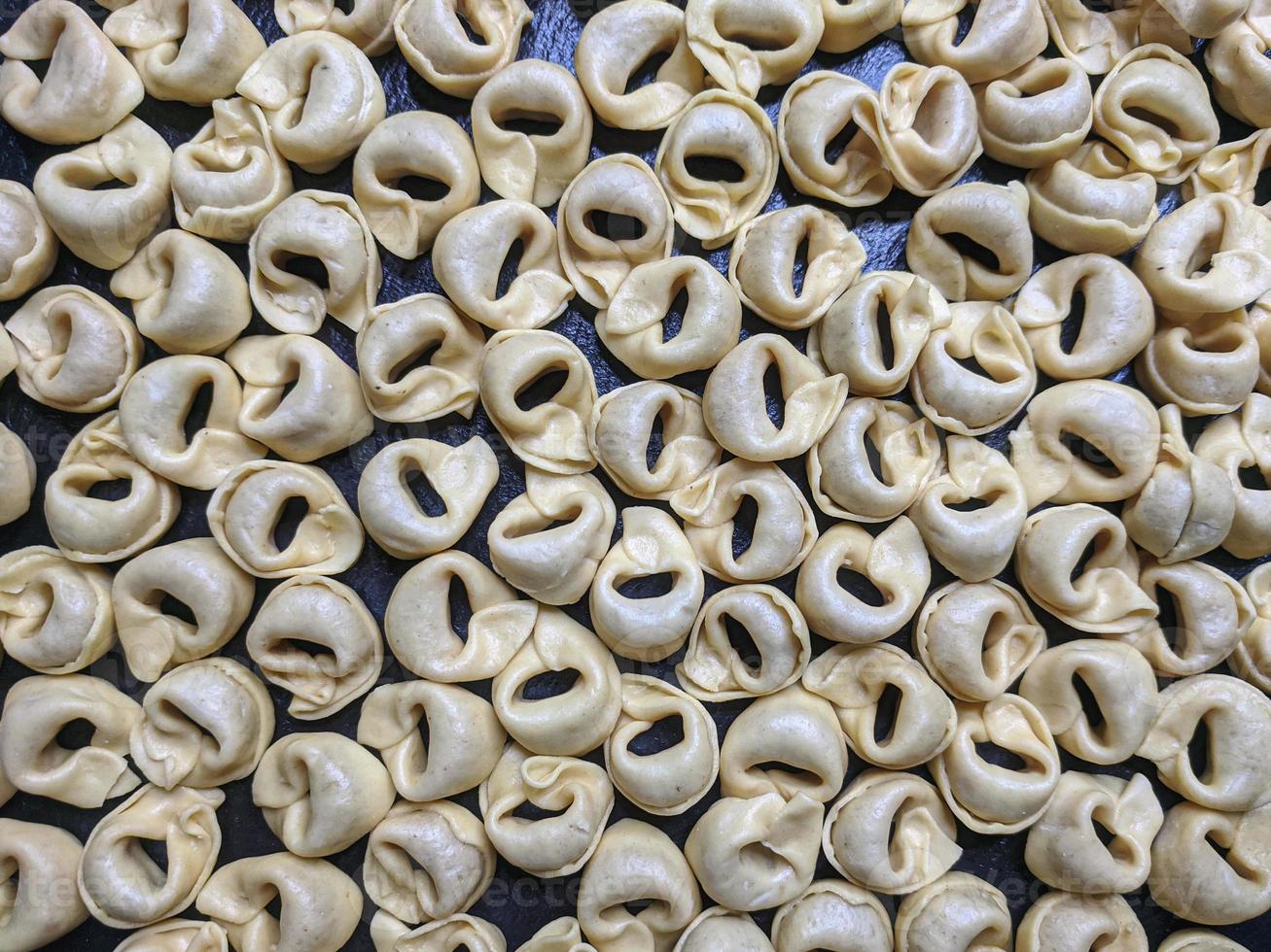 uma fechar acima topo Visão tiro do cru tortellini com branco cogumelos textura Comida fotografia foto