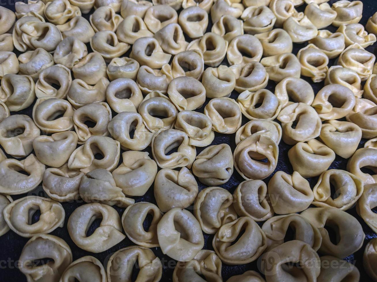 uma fechar acima topo Visão tiro do cru tortellini com branco cogumelos textura Comida fotografia foto