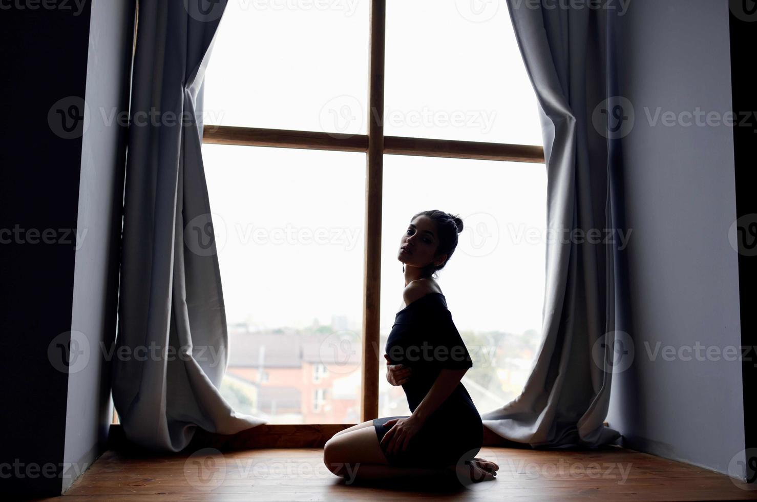 silhueta do mulher posando perto janela modelo foto