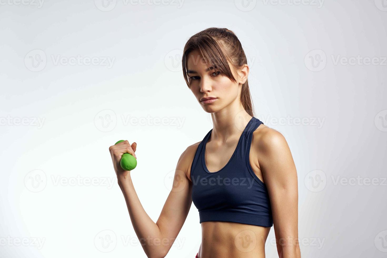 mulher segurando halteres exercite-se ginástica fino figura músculos foto