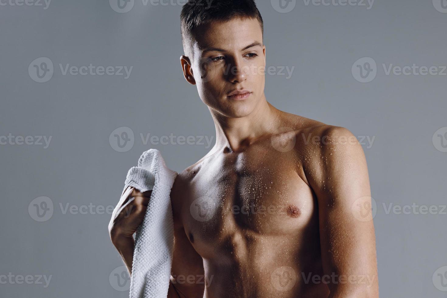 bonito homem esporte exercite-se toalha dentro mão músculos foto