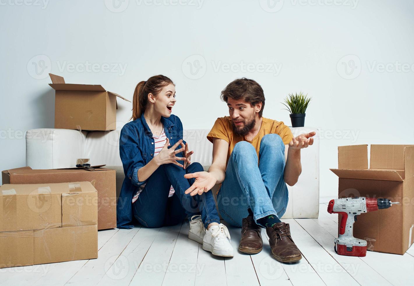 homem e mulher comovente apartamento flor em vaso e caixas reparar Ferramentas foto
