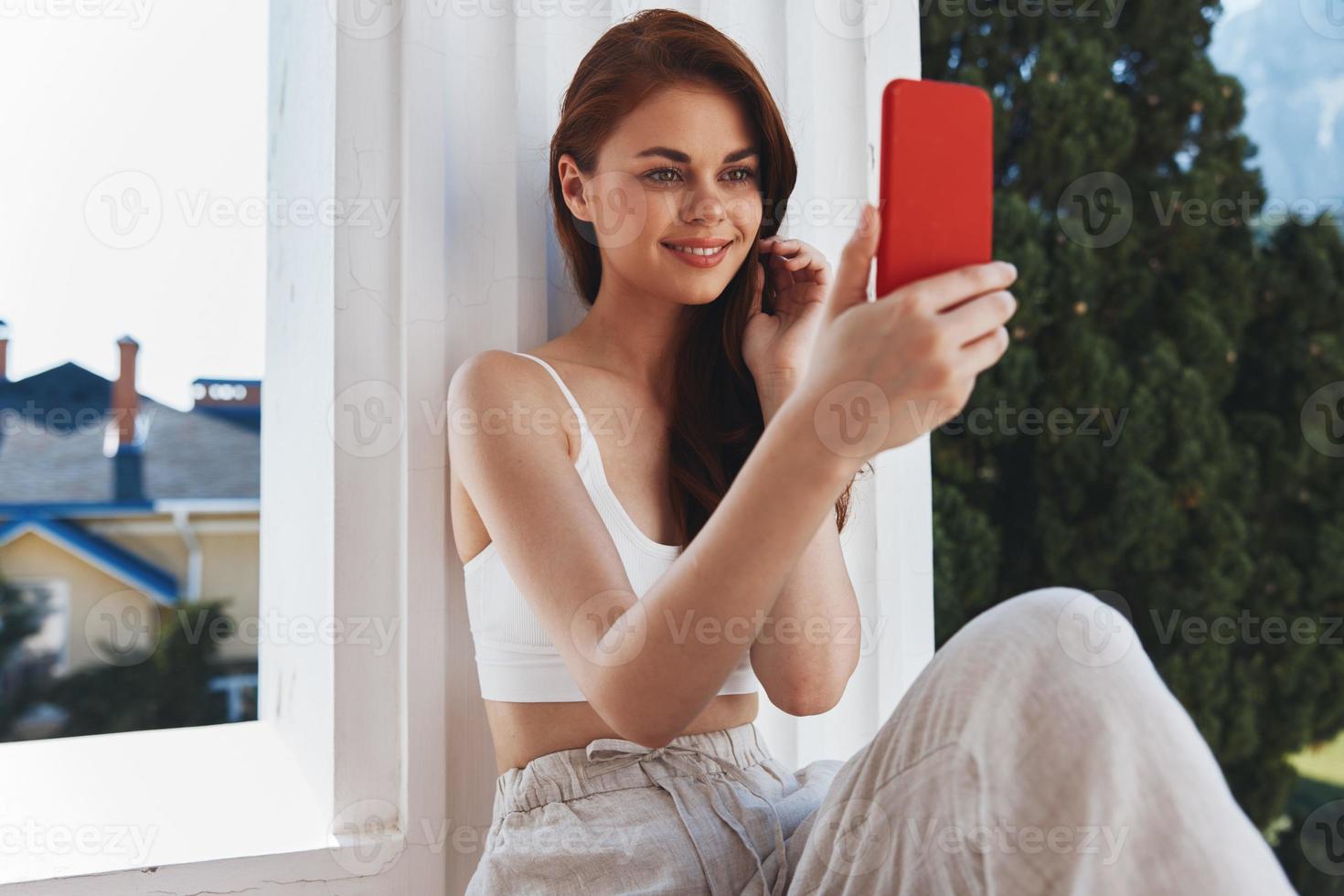 alegre mulher com uma vermelho telefone terraço ao ar livre luxo panorama lazer relaxamento conceito foto