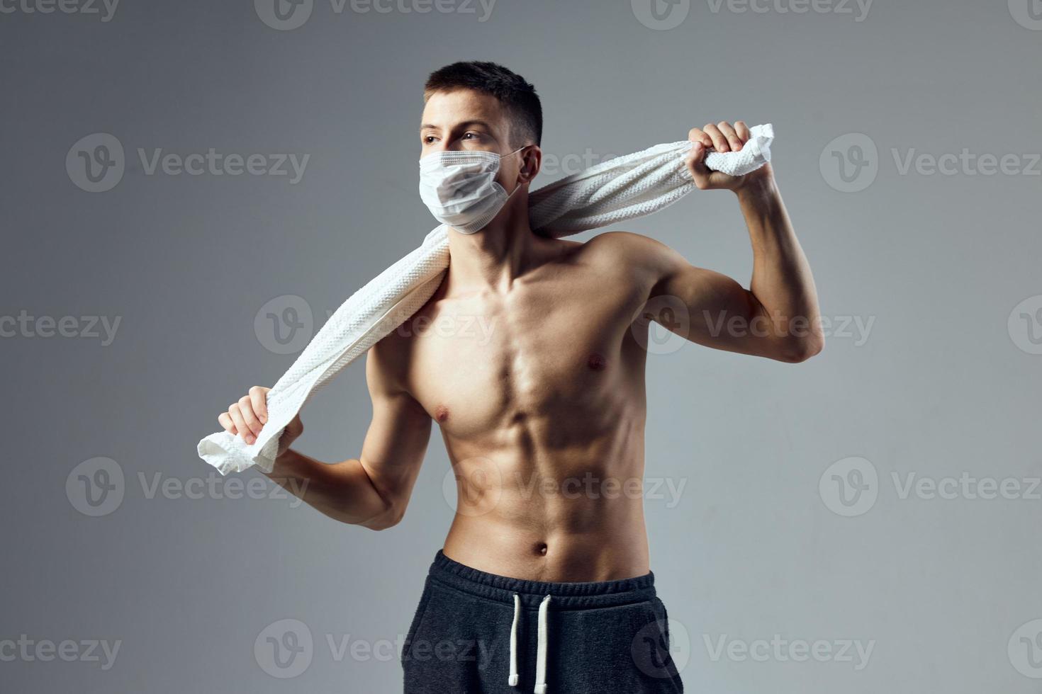 esporte homem segurando toalha atrás cabeça inflado pressione médico mascarar isolado fundo foto