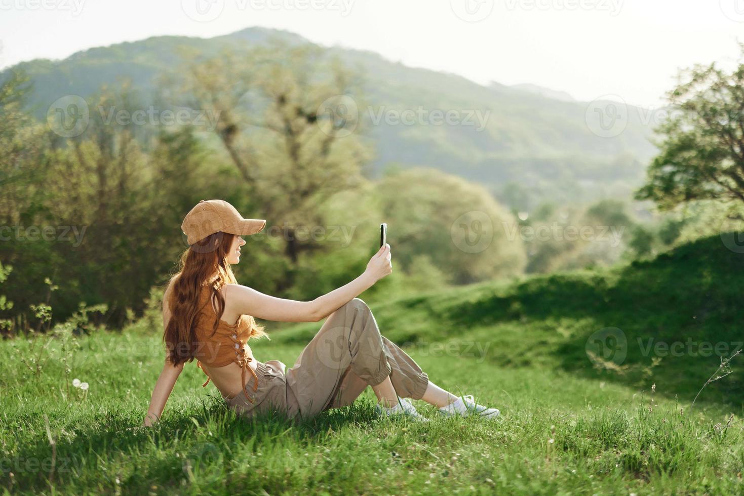 inferior Visão jovem aluna trabalhador autonomo mulher dentro verde Jaqueta jeans sentar em Banco dentro Primavera parque ao ar livre conversa de Móvel célula telefone Veja aparte. pessoas urbano estilo de vida conceito foto