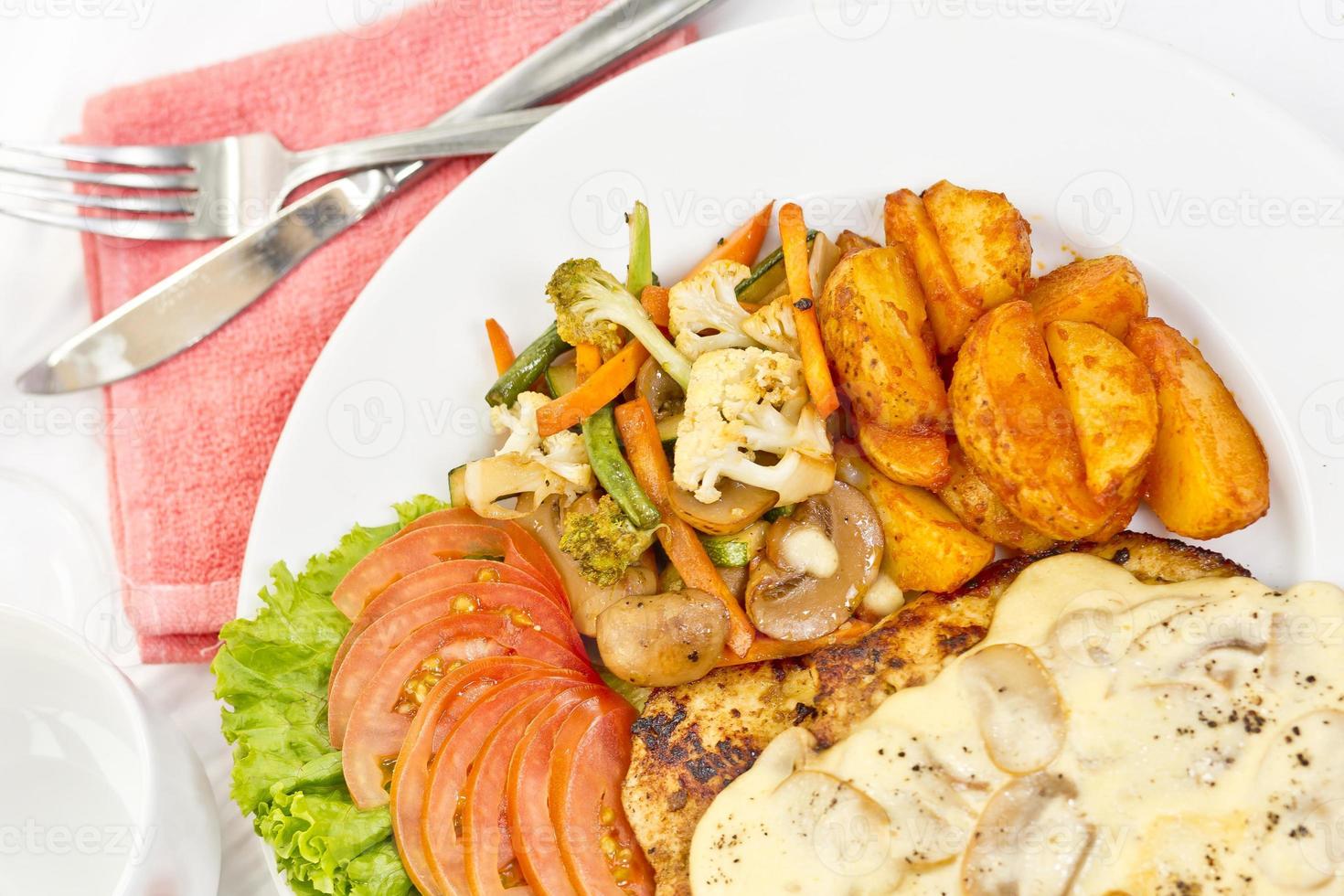 peri peri frango com botão cogumelo molho, refogue vegetais, picante frito batatas com tomate alface salada. foto