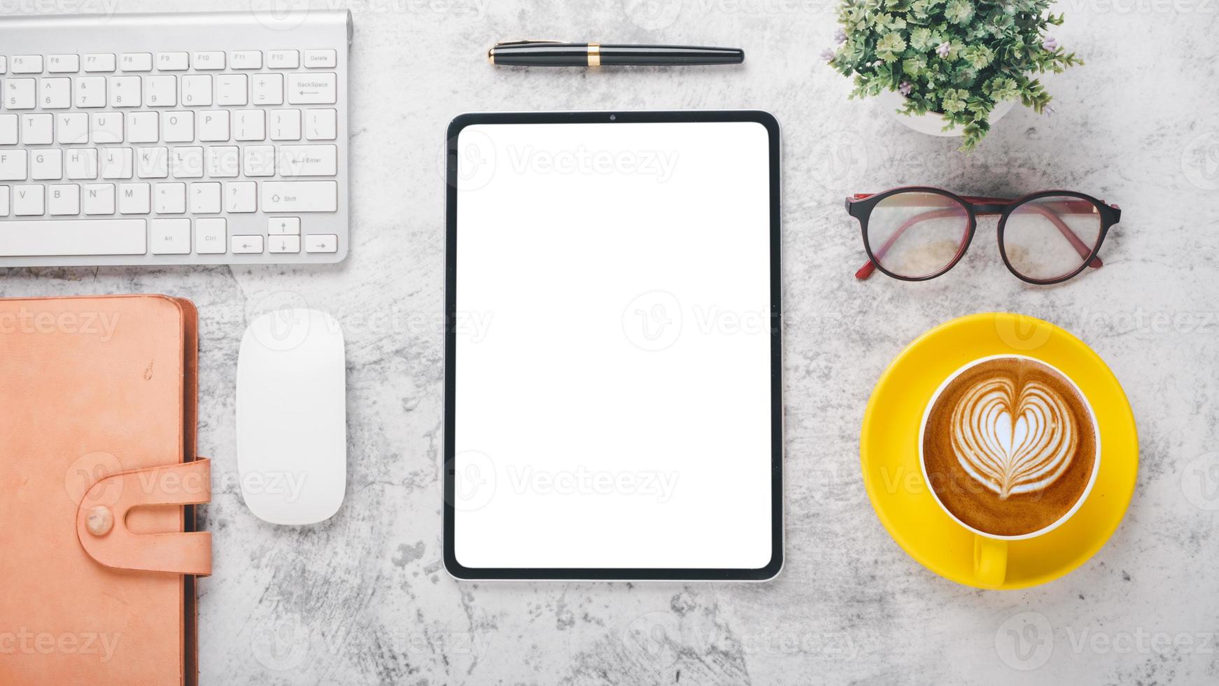 moderno escritório escrivaninha local de trabalho com em branco tela tábua, teclado, mouse,noebook, caneta, óculos e copo do café, topo Visão plano deitar com cópia de espaço. foto