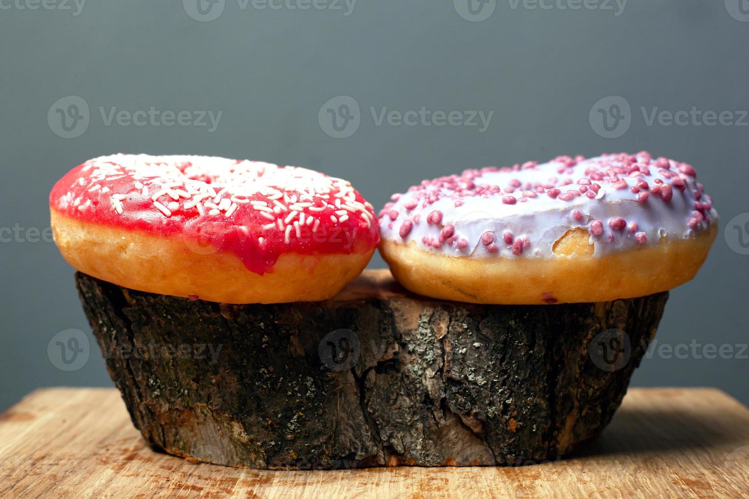 rosquinhas coloridas em toco de madeira foto