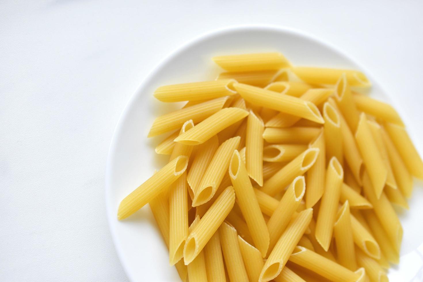 Close-up de macarrão delicioso amarelo em um prato branco foto