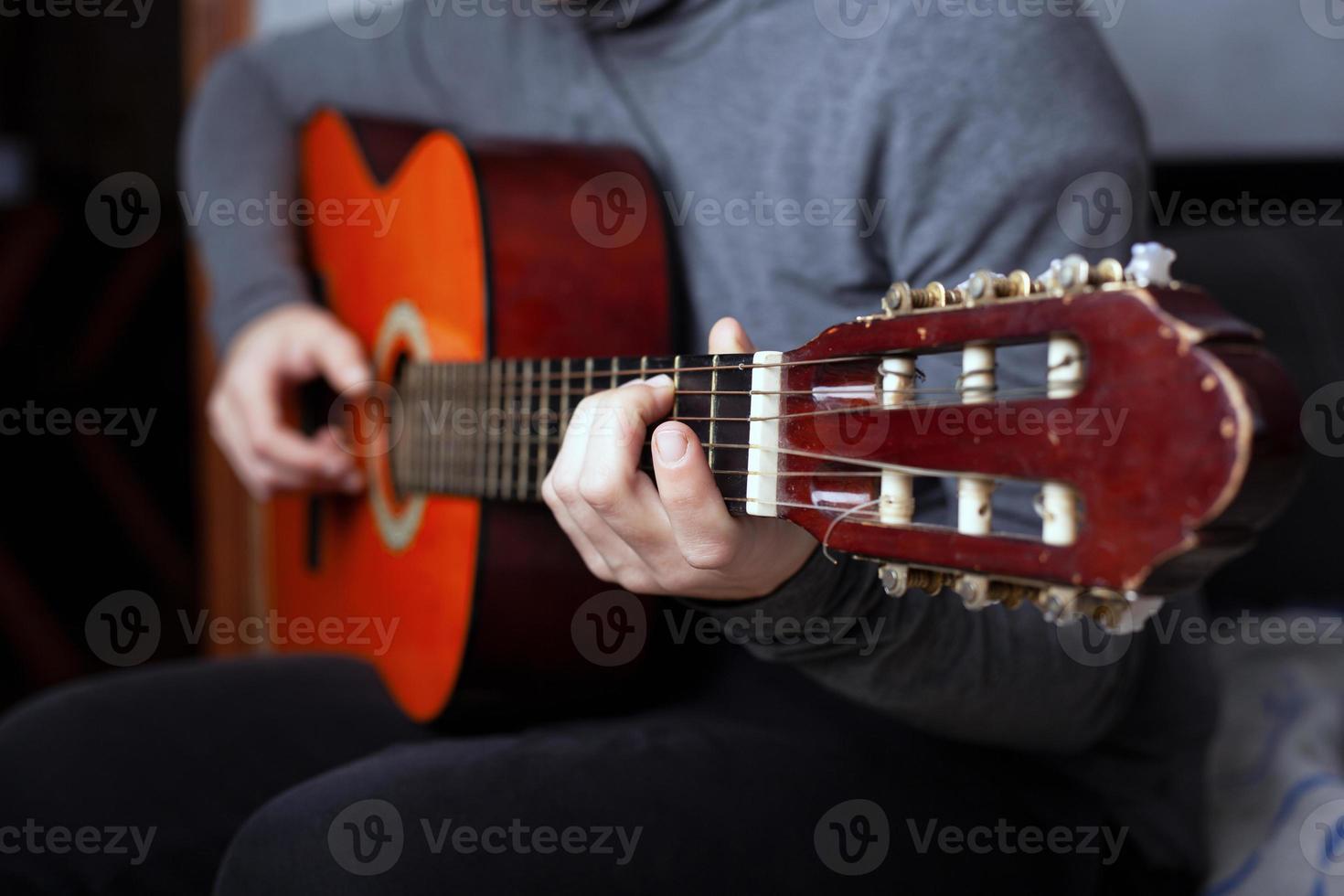 garota tocando um violão de seis cordas com cordas de náilon foto