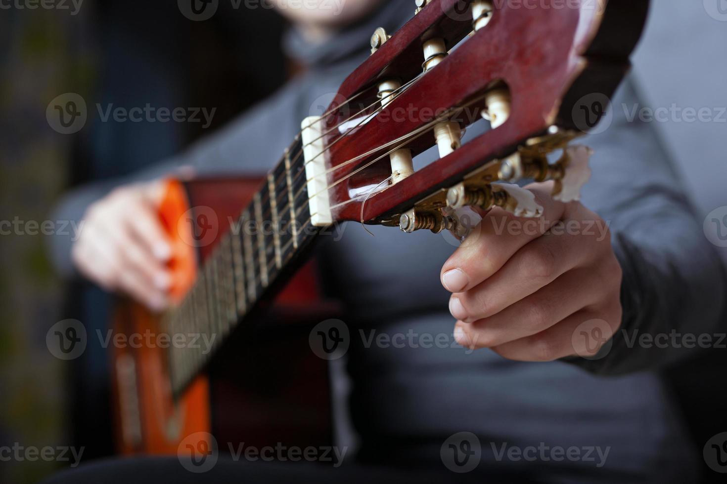 garota afina um close-up de violão foto