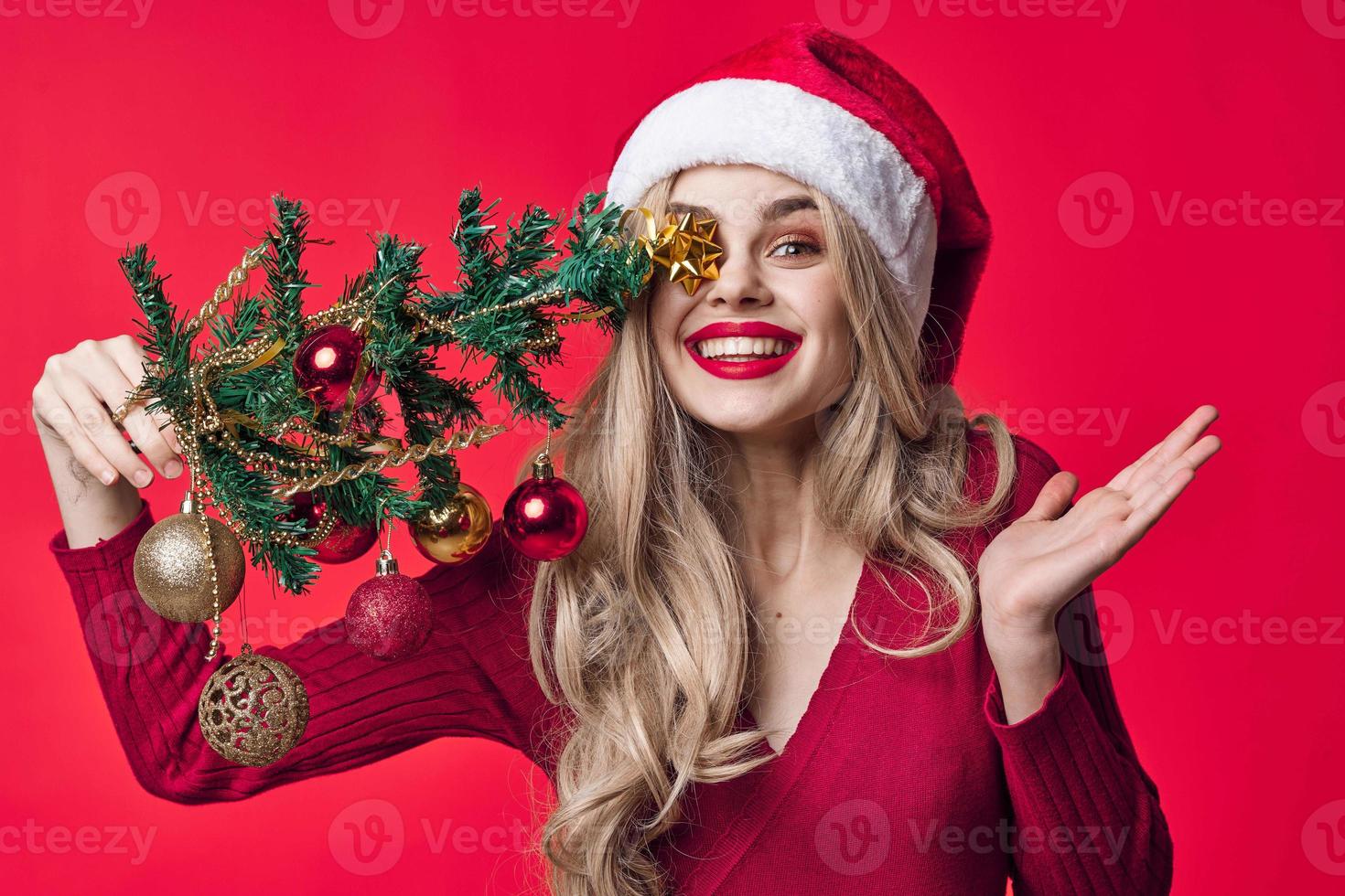 bonita mulher dentro santa claus traje segurando uma Natal árvore dentro dela mãos alegria Rosa fundo foto