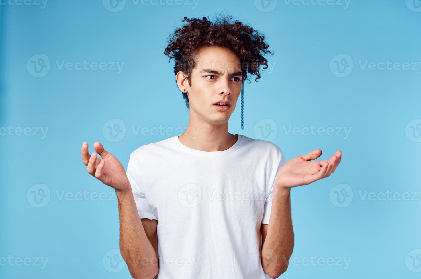 indignado cara com uma pente dentro encaracolado cabelo em uma azul fundo cópia de espaço foto