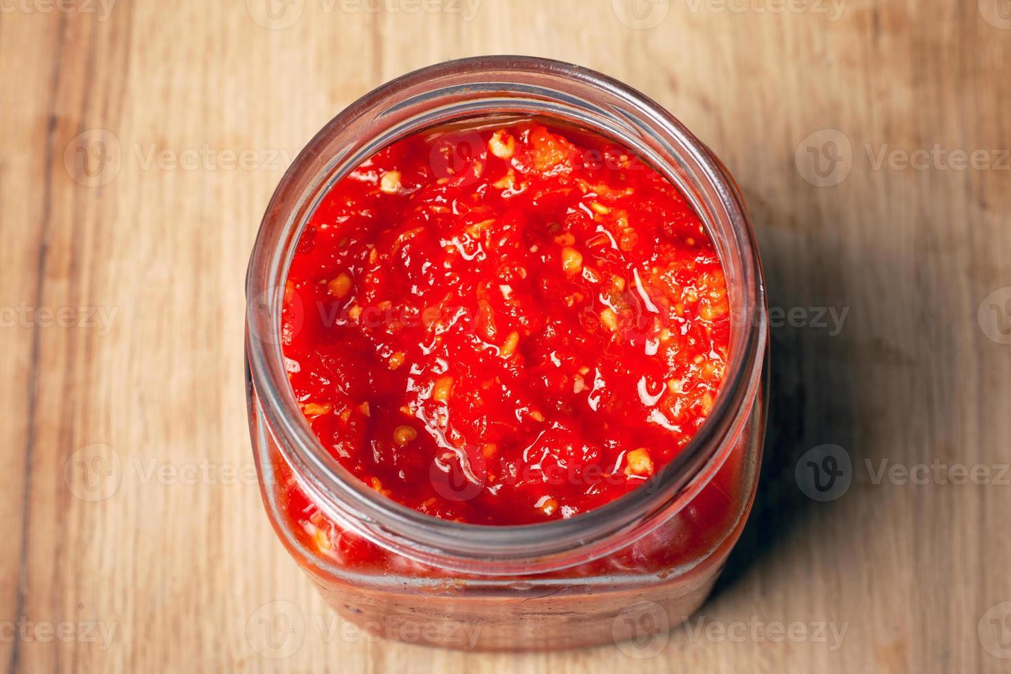 jarra com pimenta vermelha e molho de tomate foto