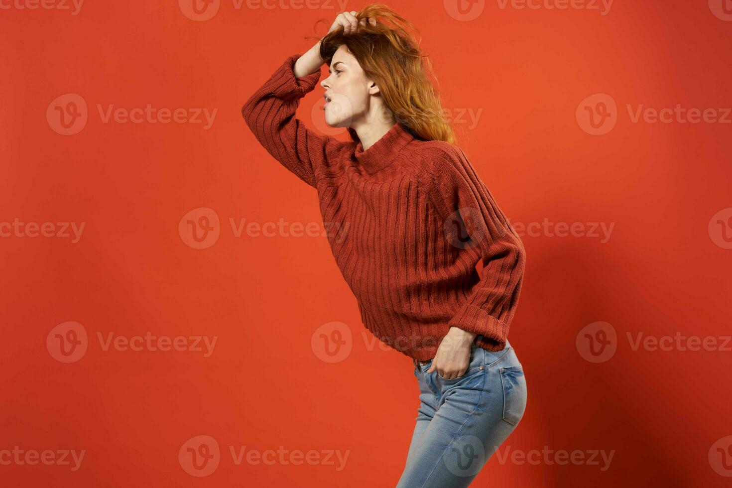 alegre mulher dentro vermelho suéter posando moda estúdio isolado fundo foto