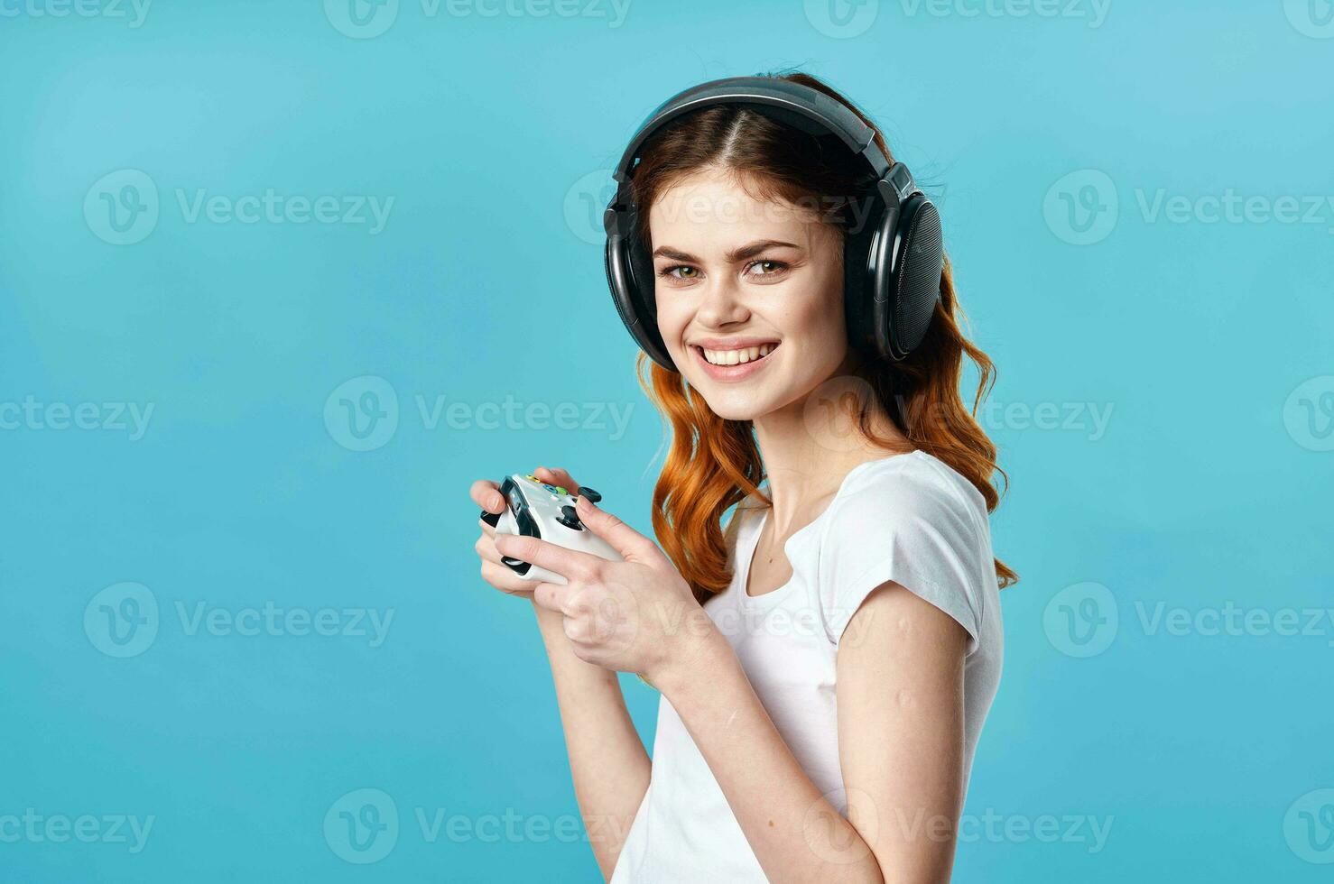 alegre menina dentro uma branco camiseta vestindo fones de ouvido controle de video game tecnologia jogos foto