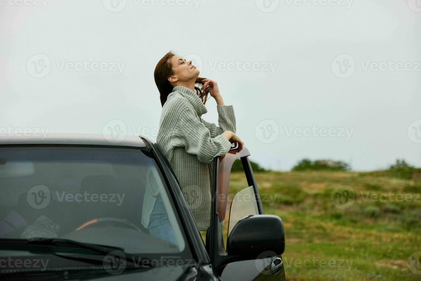 lindo mulher com vermelho cabelo dentro uma suéter perto a carro natureza fêmea relaxante foto