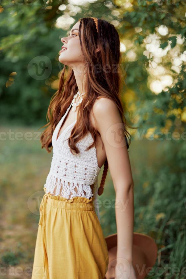 uma jovem hippie mulher dançando alegremente e sorridente sinceramente dentro natureza dentro a cair. a conceito do econômico consumo e autocuidados foto