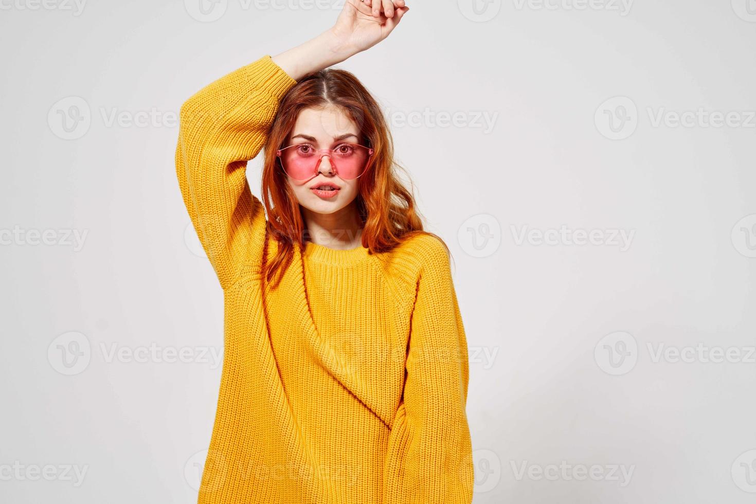 retrato do uma mulher dentro uma amarelo suéter Penteado luz fundo foto