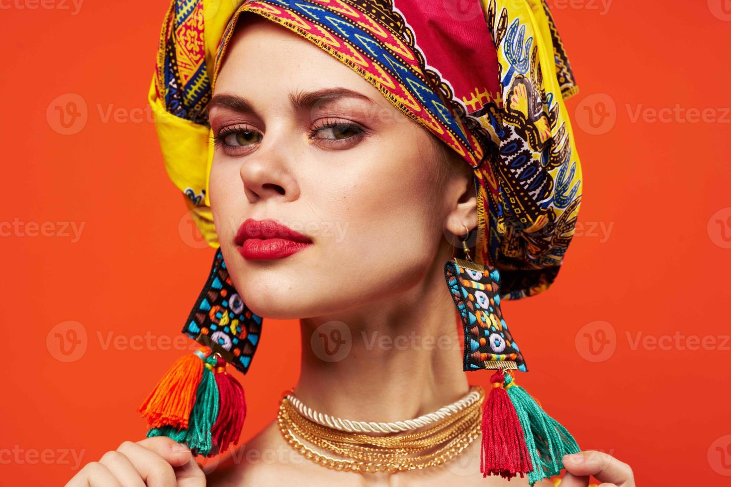 mulher dentro multicolorido turbante com Maquiagem em dela face laranja fundo foto