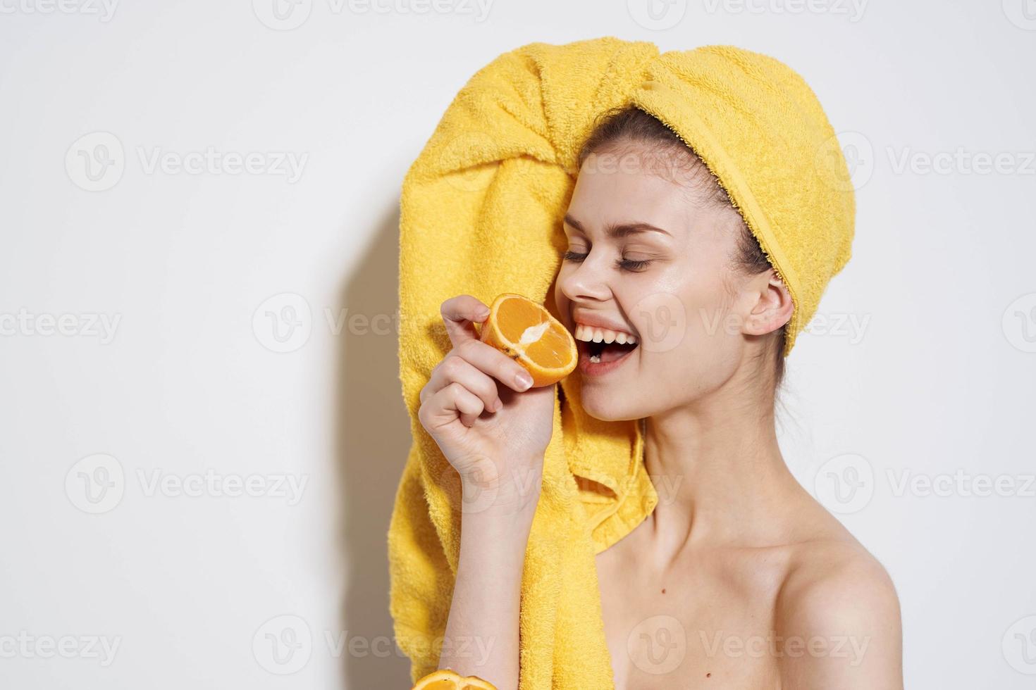 bonita mulher você amarelo toalha em cabeça laranjas citrino limpar \ limpo pele luz fundo foto