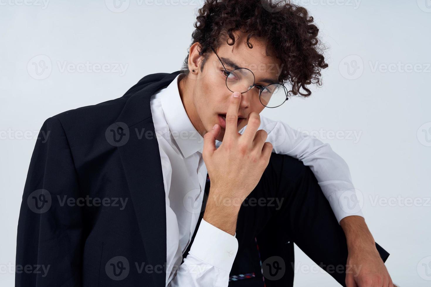 bonito cara dentro uma Jaqueta e camisa e óculos dentro uma brilhante quarto foto estúdio modelo Penteado encaracolado cabelo