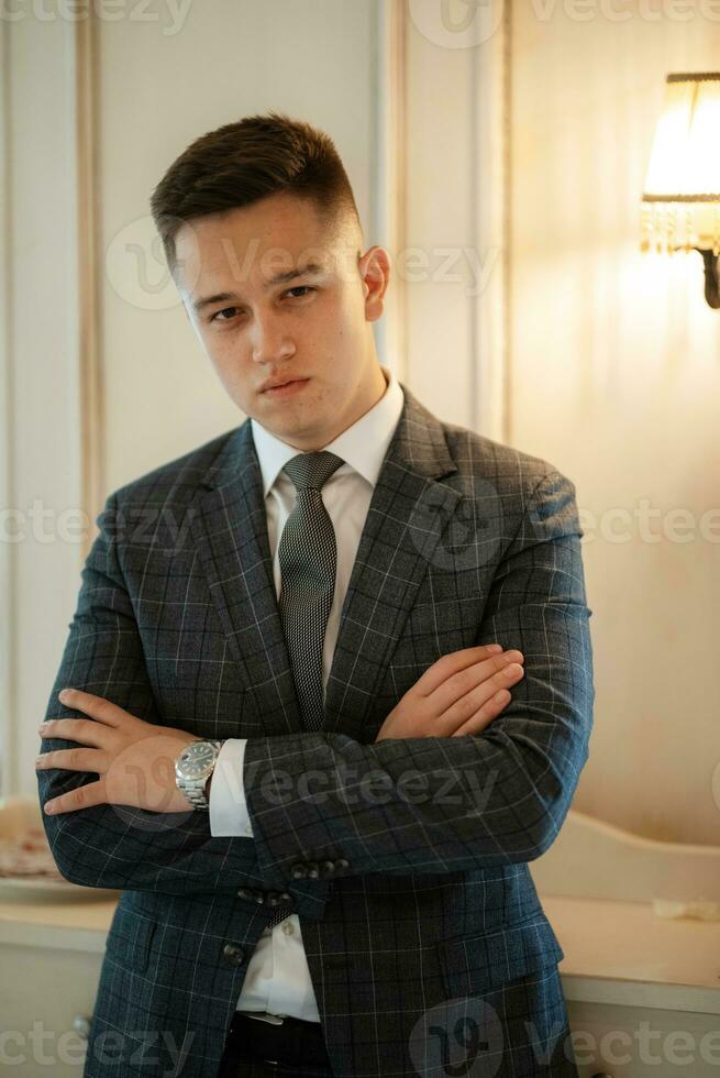 retrato do uma noivo dentro uma cinzento xadrez terno com uma gravata dentro uma luz Barra foto
