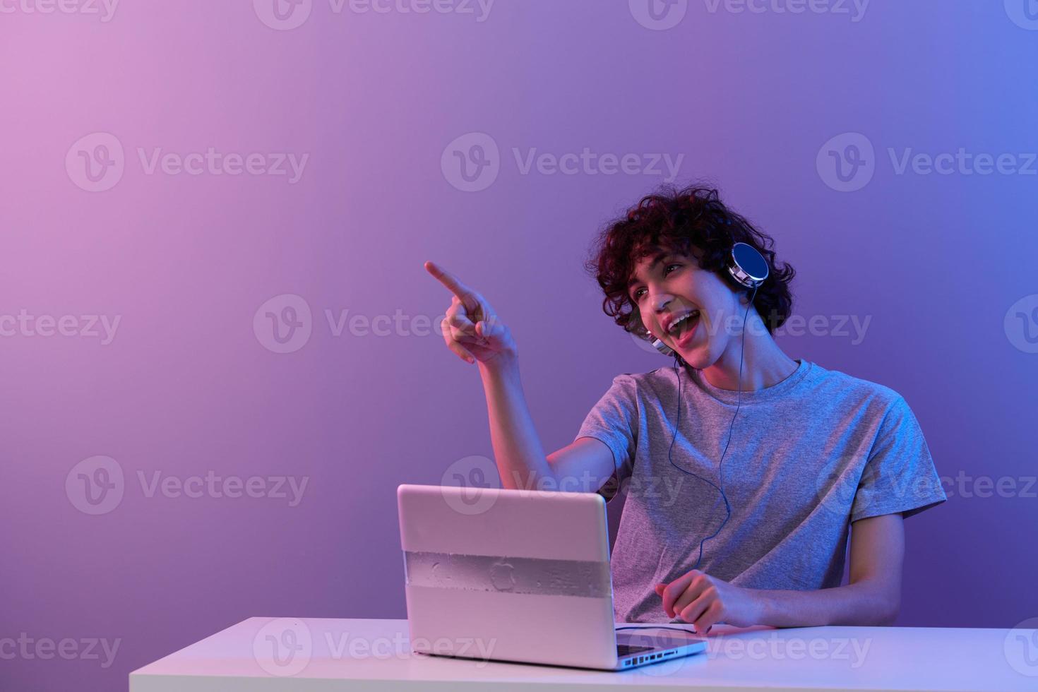 homem dentro fones de ouvido dentro frente do computador portátil entretenimento isolado fundo foto