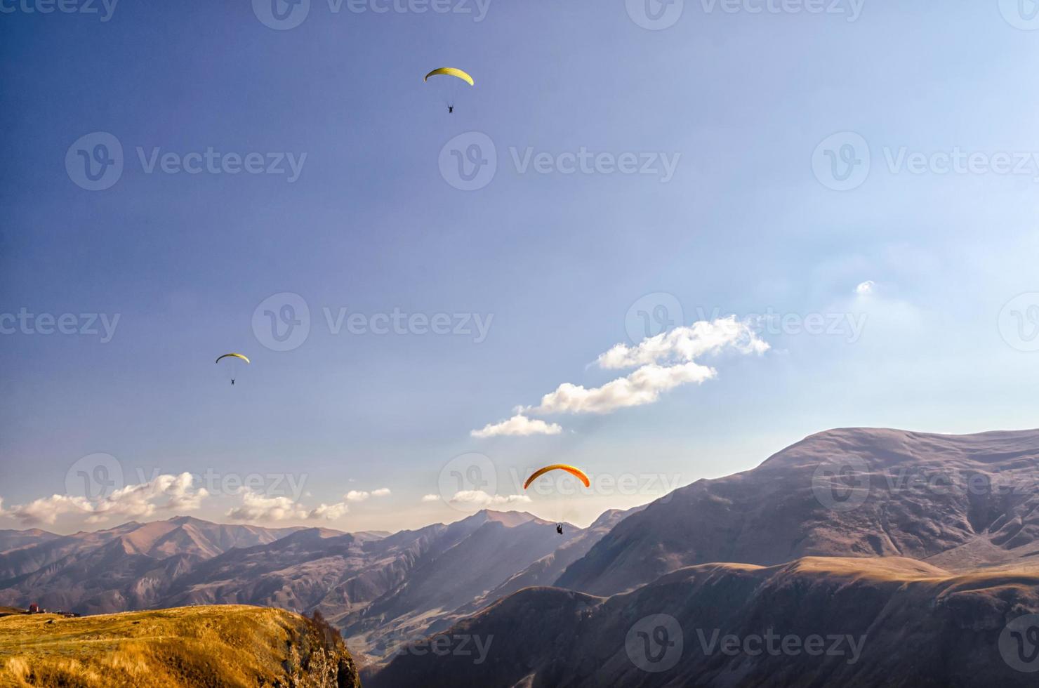 três parapentes no céu foto