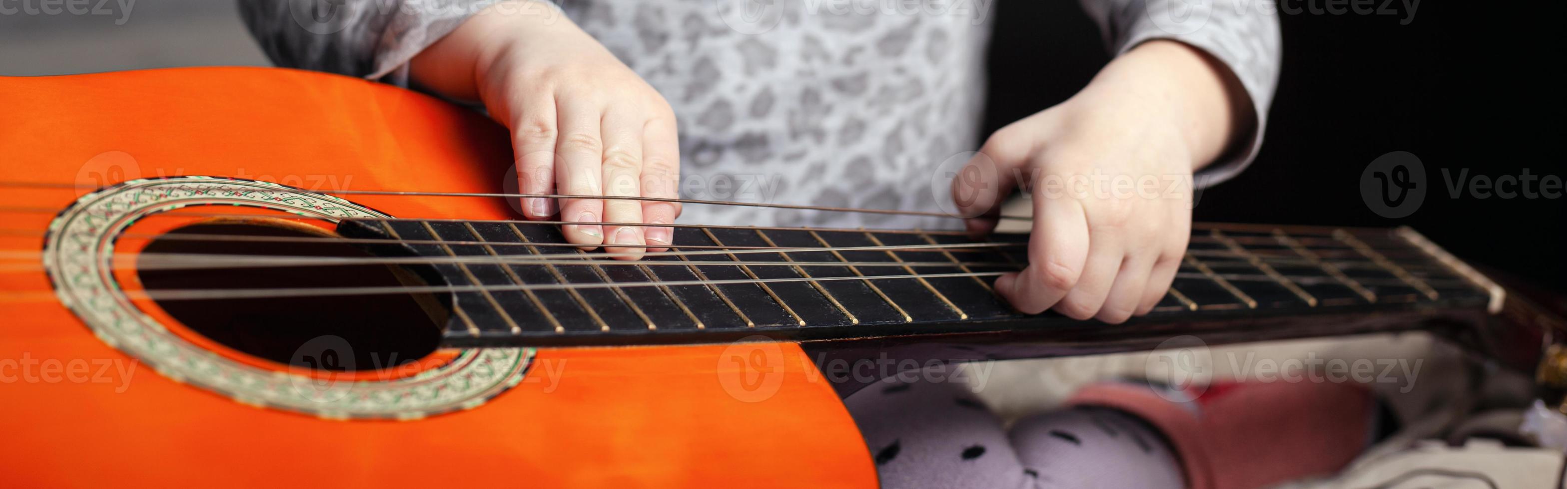 guitarra e criança pequena, foto panorâmica com tema musical