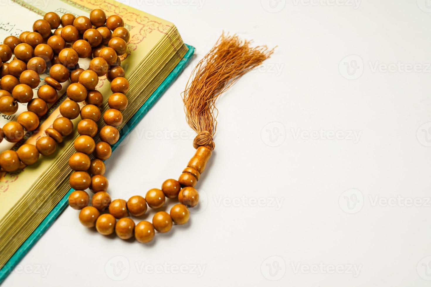 a piedosos al Alcorão com escrito árabe caligrafia significado do al Alcorão e rosário miçangas ou tasbih em branco fundo com cópia de espaço. foto