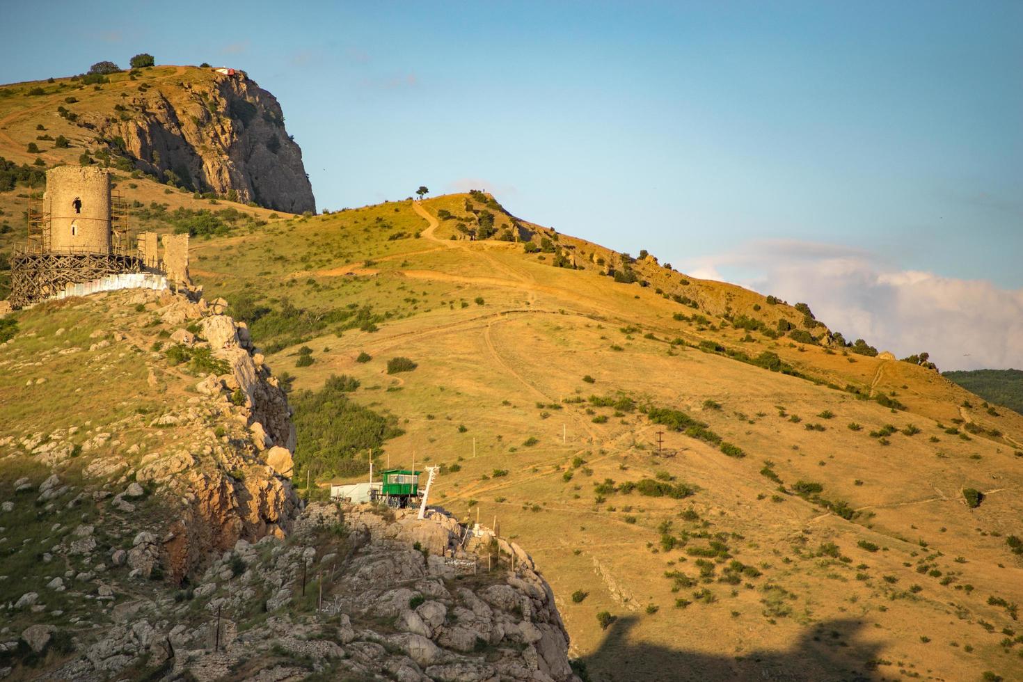 vista da fortaleza genovesa na encosta de uma montanha com um céu azul nublado na Crimeia foto