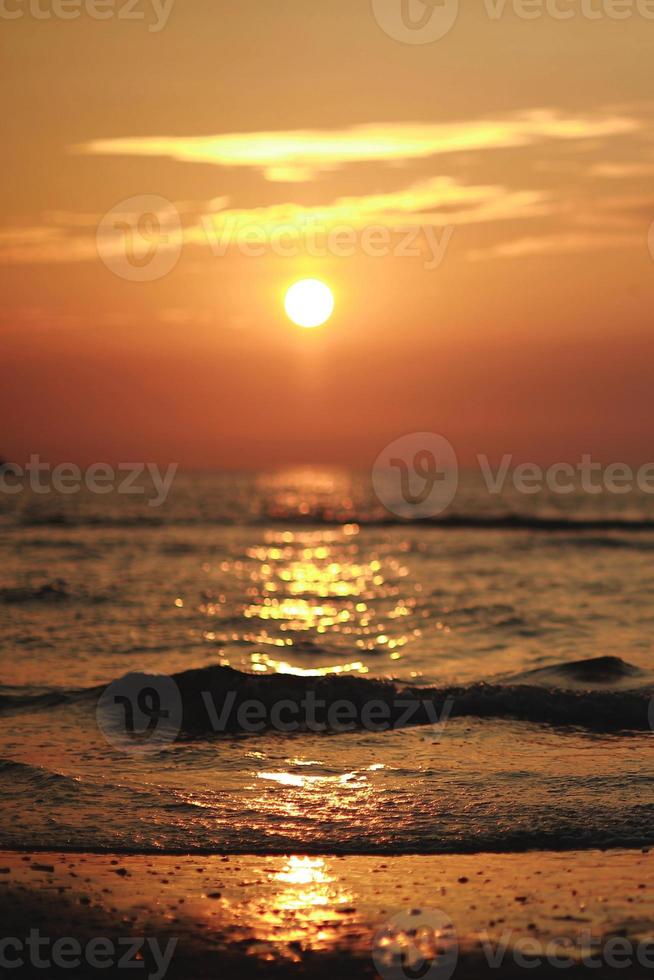 belo pôr do sol laranja brilhante em uma praia, sem imagem de filtro. vista incrível com mar do norte ao pôr do sol foto