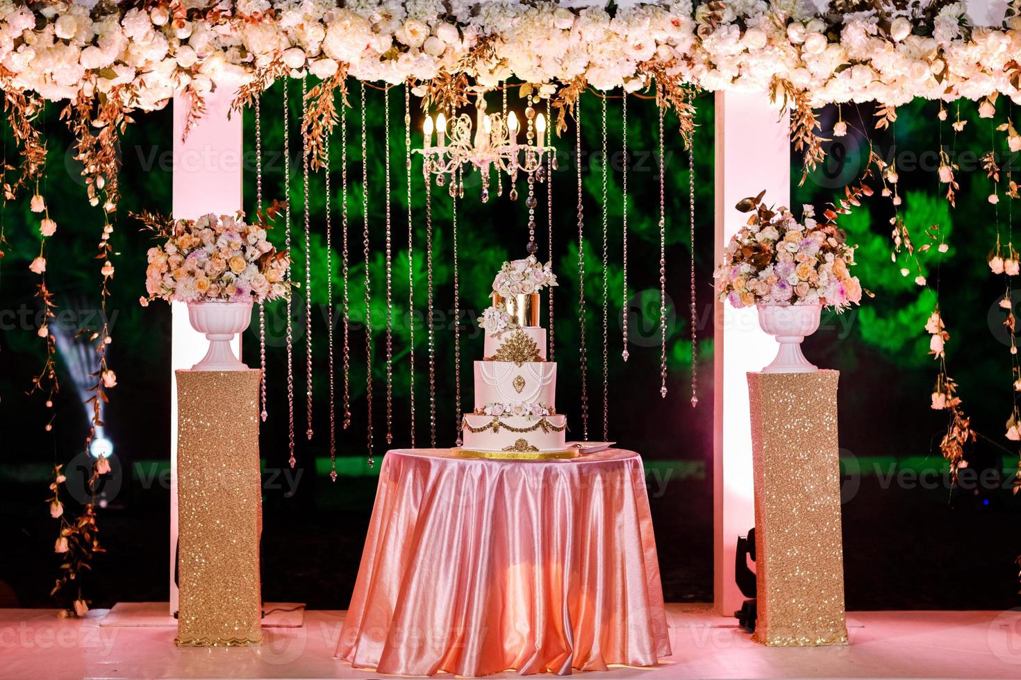 decorações de casamento. mesa com um bolo de casamento, velas, luz e flores. foto