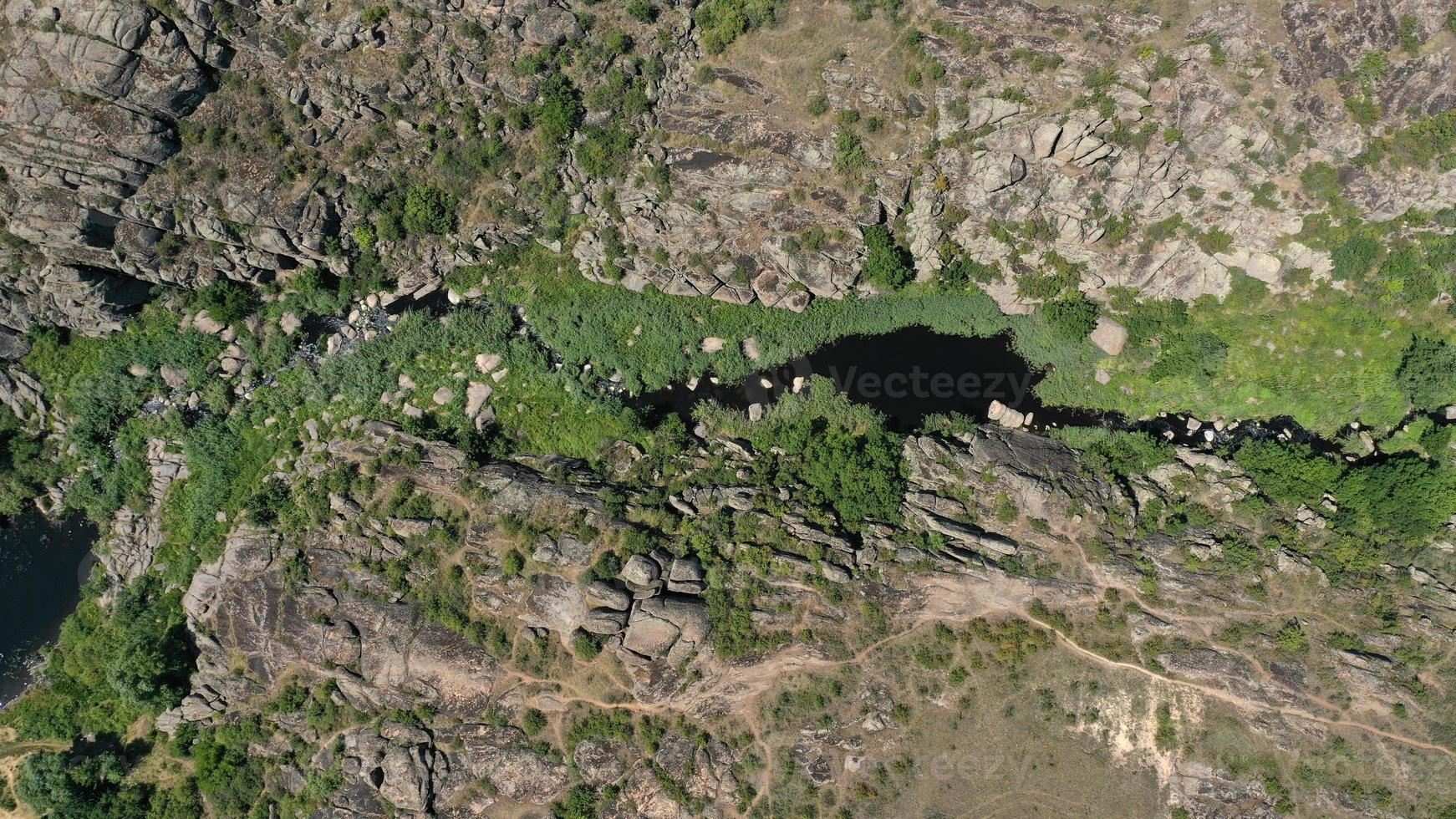 vista aérea das texturas e padrões das rochas e do rio da montanha com fendas e verdes foto